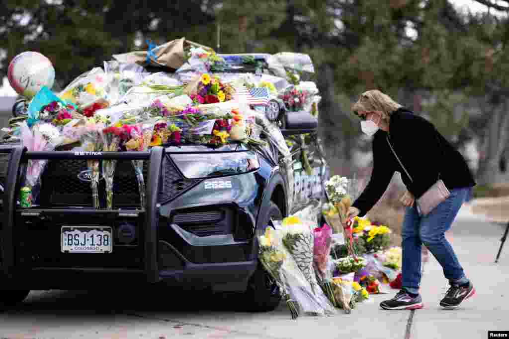 Karla Bielanski places flowers on the car of Officer Eric Talley, who was killed during a mass shooting at the King Soopers grocery store, outside the Boulder Police Department, in Boulder, Colorado, March 23, 2021.