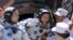 Liu Yang, center, China's first female astronaut, waves next to her comrade Jing Haipeng, left, as she exits re-entry capsule of China's Shenzhou 9, Siziwang Banner, Mongolia, June 29, 2012 file photo.