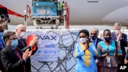 Uganda's Minister of Health Dr. Jane Ruth Aceng, center right, and other officials greet the country's first consignment of AstraZeneca COVID-19 vaccine manufactured by the Serum Institute of India at the airport in Entebbe, Uganda March 5, 2021.