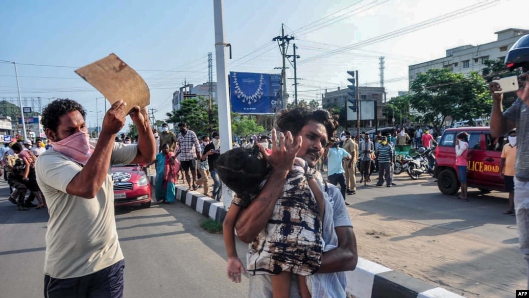 A man carries a fainted young girl to evacuate her following a gas leak at an LG Polymers plant in Visakhapatnam on May 7, 2020. 