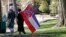 FILE -A couple leaves the grounds of the state Capitol in Jackson, Miss., after participating in a rally in support of keeping the Confederate battle emblem on the state flag, Jan. 19, 2016.