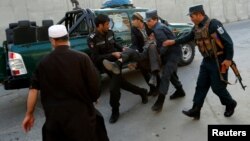 阿富汗警察抬着一个在喀布尔被炸伤的男子 (2017年10月31日)