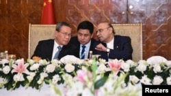 Pakistani President Asif Ali Zardari, right, and Chinese Premier Li Qiang, left, interact during a state luncheon in Islamabad, Pakistan, on Oct. 15, 2024. (Pakistan's Press Information Department via Reuters)