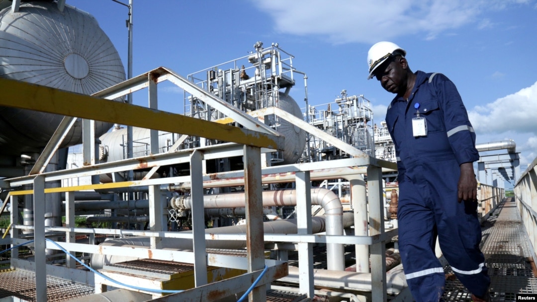 FILE - A worker walks by an oil well at the Toma South oil field in Ruweng state, South Sudan, Aug. 25, 2018.