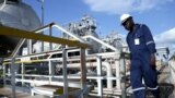 FILE - A worker walks by an oil well at the Toma South oil field in Ruweng state, South Sudan. Taken Aug. 25, 2018.