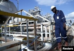 FILE - A worker walks by an oil well at the Toma South oil field in Ruweng state, South Sudan, Aug. 25, 2018.