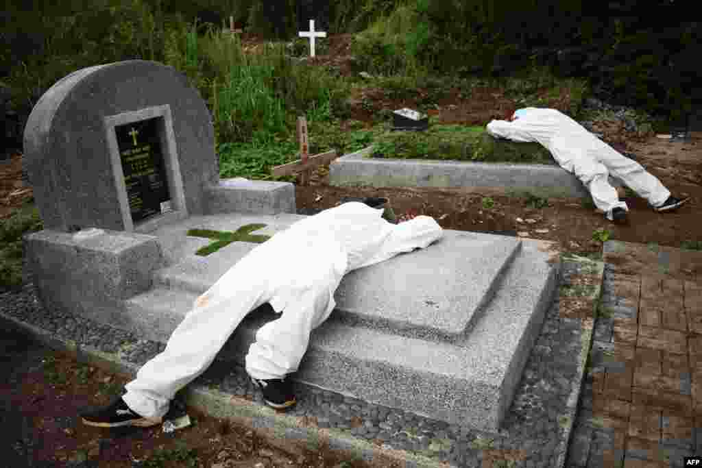 신종 코로나바이러스 감염 사망자들의 매장지로 지정된 인도네시아 반둥의 한 묘지에서 구덩이를 파다 지친 인부들이 누워서 쉬고 있다.