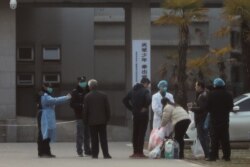 Medical staff and security personnel stop patients' family members from being too close to the Jinyintan hospital in Wuhan, Hubei province, China, Jan. 20, 2020.