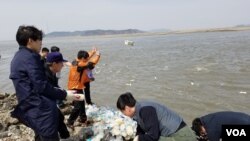 한국의 탈북자 단체 관계자들이 지난 4월 강화도에서 쌀과 이동식저장장치(USB) 등이 들어 있는 페트병을 바다에 던지고 있다. (자료사진)