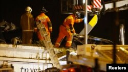 Tim SAR memeriksa reruntuhan helikopter polisi yang jatuh minimpa atap pn "Clutha Vaults" di Glasgow, Skotlandia (30/11).