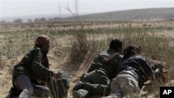 Libyan rebel take their position during a battle against pro-Moaamar Gadhafi fighters, in the town of Brega, east of Libya, March 2, 2011.