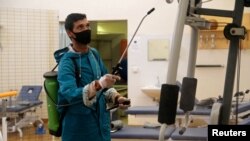An employee from a disinfection service company wears a protective mask while sanitizing sports equipment at the gym of Benghazi Medical Center, following the outbreak of the coronavirus disease (COVID-19), in Benghazi, Libya, Aug. 6, 2020. 