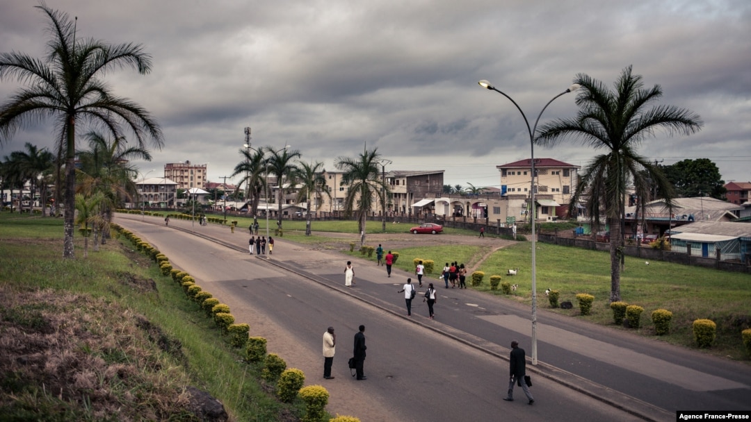 FILE - People walk by the entrance of the University of Buea, South-West Region of Cameroon, on April 27, 2018.