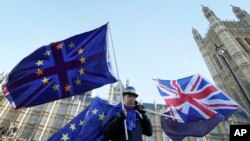 An anti Brexit demonstrator waves EU and British flags in Westminster in London, Dec. 8, 2017. 