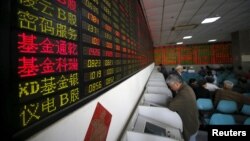 Investors look at computer screens showing stock information at a brokerage house in Shanghai, China, April 21, 2016. 