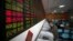 Investors look at computer screens showing stock information at a brokerage house in Shanghai, China, April 21, 2016. 