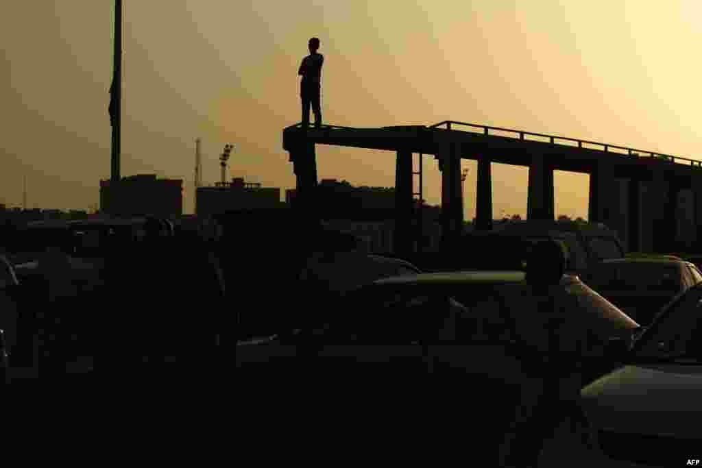 A silhouette of a Libyan man is seen during a protest against a new government proposed by U.N. envoy Bernardino Leon, in the eastern city of Benghazi. World leaders urged Libya&#39;s warring parties to sign a proposed peace deal installing a national unity government, after a cool response from some lawmakers in the country&#39;s rival parliaments.