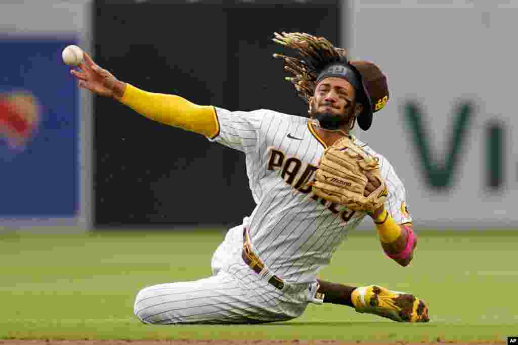 San Diego Padres shortstop Fernando Tatis, Jr. throws to first as Pittsburgh Pirates&#39; Adam Frazier arrives safely for a single during the third inning of a baseball game in San Diego, California, May 5, 2021.