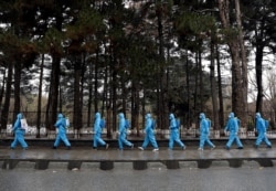 FILE - Volunteers prepare themselves to spray disinfectants on streets and shops amid concerns about coronavirus disease (COVID-19) in Kabul, Afghanistan, March 30, 2020.