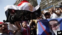 Para pendukung Hazem Abu Ismail memegang poster dan melambaikan bendera nasional Mesir di depan pengadilan Kairo, Mesir (11/4). (Foto: Dok)