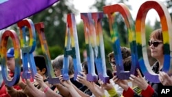 Cộng đồng LGBT cầm biểu ngữ tưởng nhớ các nạn nhân thiệt mạng trong vụ xả súng ở Orlando.