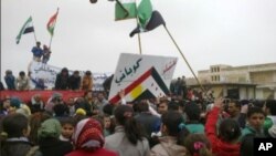 Kurd li bajarê Kobanî'yê derdikevin kolanan û Serhildana 12'ê Adarê bibîr tînin. Adar, 12, 2012