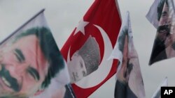 Supporters of the pro-Kurdish Peoples' Democratic Party, (HDP) wave a flag, center, with Turkish Republic founder Mustafa Kemal Ataturk, and others of imprisoned Kurdish rebel leader Abdullah Ocalan, during a rally in Istanbul, Turkey.