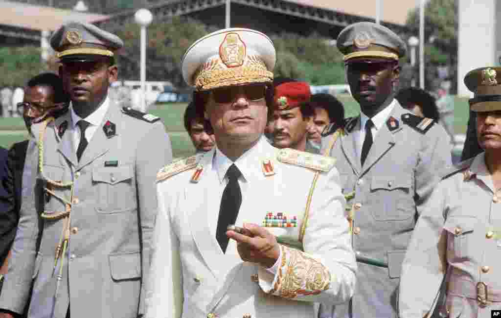 Libyan Head of State Colonel Moamer Kadhafi (C) reviews troops 03 December 1985 in Dakar upon his arrival for three-day official visit to Senegal. Kadhafi, born in 1942, formed in 1963 the Free Officers Movement, a group of revolutionary army officers, wh