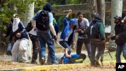 Un estudiante sufre una paliza en la Universidad Central de Caracas a manos de grupos pro gubernamentales.