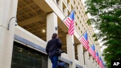 A member of the news media walks in front of the FBI headquarters building early in the morning in Washington, May 10, 2017. President Donald Trump fired FBI Director James Comey Tuesday evening. 