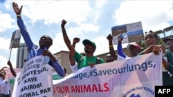FILE - Environmental activists chant slogans as they carry placards and banners during a protest in Nairobi, Kenya, March 1, 2018, against a government decision to construct a standard-gauge railway line across the Nairobi National Park. 