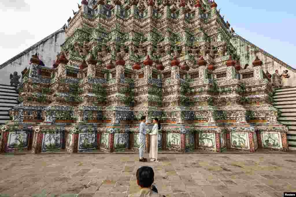 Otros esperan el día para hacer una romántica propuesta o para dar el gran &quot;Sí&quot;. En Bangkok, Tailandia, una pareja de novios celebra su unión en el imponente Templo del Amanecer.