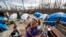 Diahnn "Shelly" Summers, right, embraces Lori Hogan, who is currently living in a tent in Summers' backyard months after Hurricane Michael hit in Youngstown, Fla, Wednesday, Jan. 23, 2019.