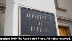 FILE - A photo shows a sign for the Department of Defense at the Pentagon building, in Arlington, Virginia, outside Washington, April 19, 2019. 