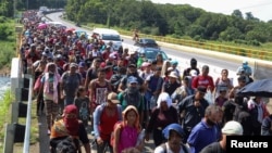 Migrantes de Centroamérica caminan en una carretera en una caravana que se dirige a la capital mexicana para solicitar asilo y estatus de refugiado, en Tapachula, en el estado de Chiapas, México, 24 de octubre de 2021.