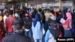 Masyarakat mengantre di depan loket tiket terminal untuk mendapatkan pengembalian uang atas tiket yang dibeli di Bekasi, Jawa Barat pada 23 April 2020, setelah pemerintah mengumumkan larangan mudik di tengah kekhawatiran penyebaran virus corona COVID-19. (