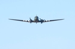 A Dakota performs a flyby at the funeral of Captain Tom Moore, in Bedford, England, Feb. 27, 2021.