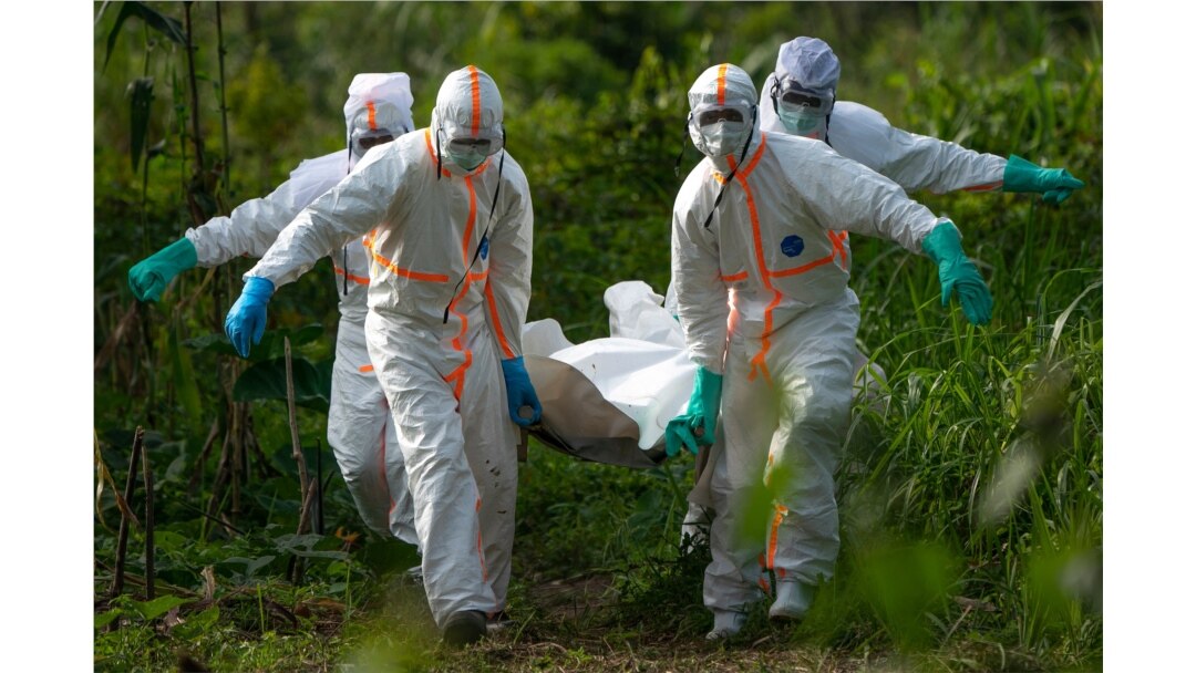 FILE - Burial workers dressed in protective gear carry the remains of an Ebola victim in Beni, DRC, July 14, 2019.