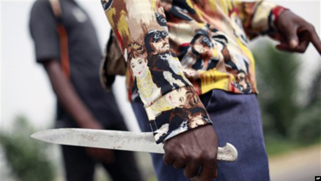 A rebel fighter holds a knife as he stands watch for security forces on a street in the Abobo neighborhood of Abidjan, Ivory Coast. Security forces loyal to Ivory Coast's incumbent leader fired volleys of gunshots, leaving at least four people dead after
