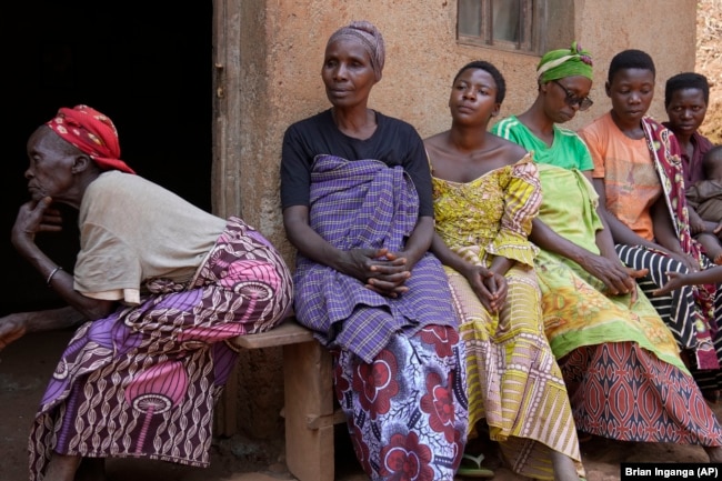 Women listen to Prudencienne Namukobwa, not pictured, as she performs akazehe, outside her house in Ngozi, Burundi, Friday, Sept. 20, 2024. (AP Photo/Brian Inganga)