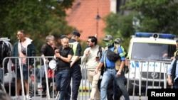 Salwan Momika, yang berencana membakar Al-Qur'an dan bendera Irak, dikawal polisi ke lokasi di luar kedutaan Irak, di Stockholm, Swedia 20 Juli 2023 lalu (foto: dok). 