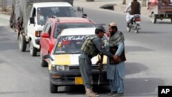 Seorang polisi Afghanistan melakukan pemeriksaan terhadap seorang warga di sebuah pos pemeriksaan di Kandahar, Afghanistan selatan (foto: dok). Tujuh polisi tewas dalam serangan oleh orang dalam di Kandahar. 