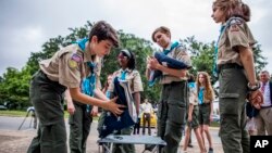 Pramuka putri dari Scouts BSA Troop 19 di Austin, Texas, melipat bendera untuk sebuah upacara bendera, di Austin, Texas, 4 Juni 2019. (Foto: Anthony Smith/The Boy Scouts of America via AP Images)