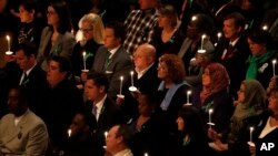 Family members of shooting victims hold candles at a vigil for victims of the shooting at Sandy Hook Elementary School in Newtown, Connectricut, Thursday, Dec. 12, 2013.