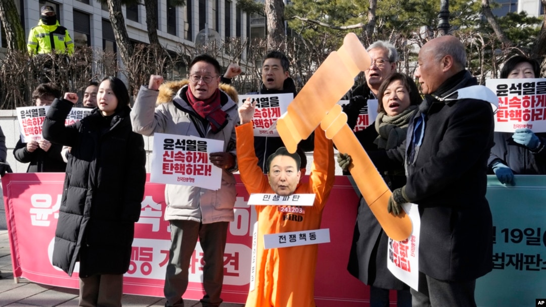 A protester wearing a mask of impeached South Korean President Yoon Suk Yeol attends with his fellow protesters during a rally calling for Yoon to step down in front of the Constitutional Court in Seoul, South Korea, Feb. 19, 2025. 