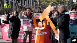 A protester wearing a mask of impeached South Korean President Yoon Suk Yeol attends with his fellow protesters during a rally calling for Yoon to step down in front of the Constitutional Court in Seoul, South Korea, Feb. 19, 2025. 