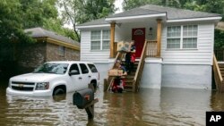 Bomberos llevan comida a los habitantes del barrio Tremont Park que quedaron atrapados por las inundaciones causadas por la tormenta tropical Debby, el martes 6 de agosto de 2024, en Savannah, Georgia.