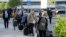 Romanian care workers with face masks accompanied by police and security arrive at the train station of Vienna's Schwechat airport, Austria, May 11, 2020.