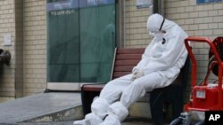 Un miembro del equipo médico se toma un descanso ante un hospital en Daegu, Corea del Sur, el domingo 23 de febrero de 2020. (Im Hwa-young/Yonhap via AP)