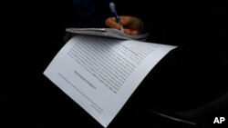 A journalist takes notes as she holds a copy of an appeal filled by Catalan branch of Spain's Citizens party at Spain's Constitutional Court in Madrid, Nov. 4, 2015. 